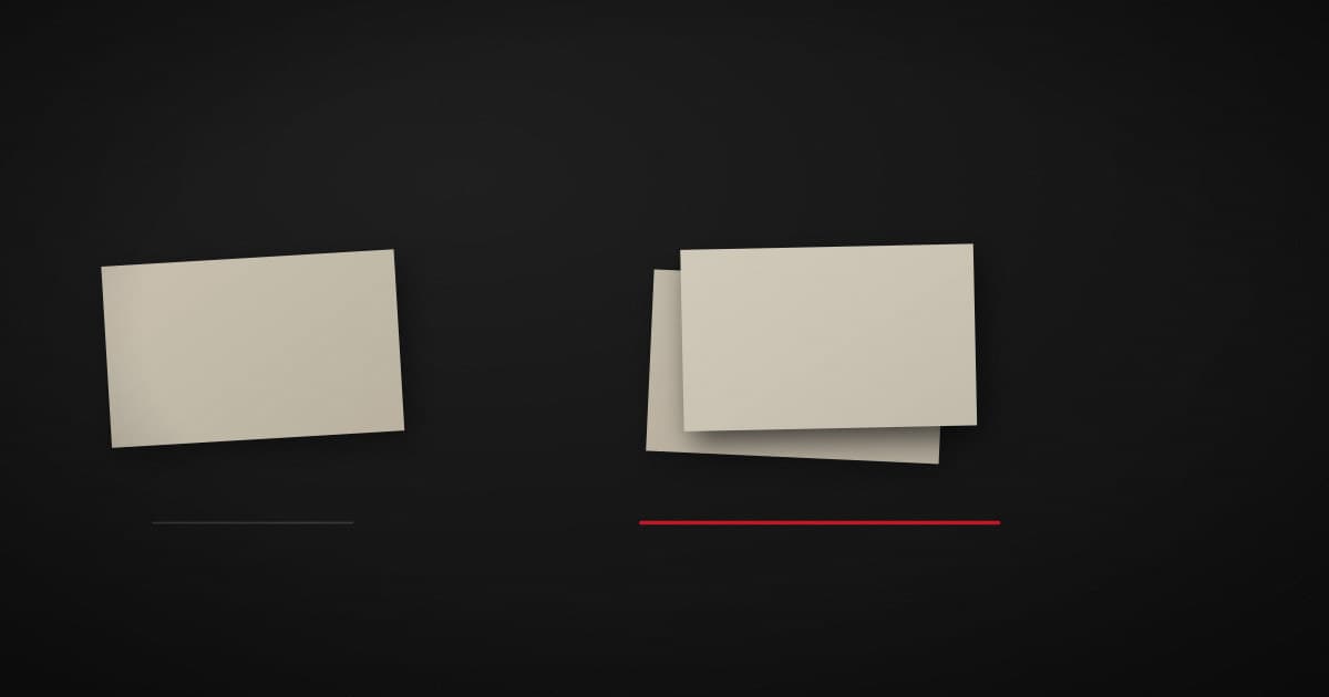 Three pale paper labels laid out on a dark surface, two of them overlapping almost exactly, with a crimson line joining the pair