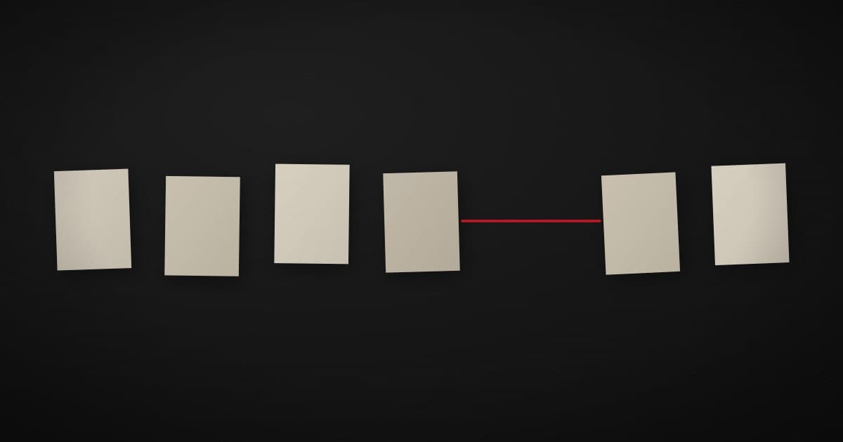 A row of pale paper cards on a dark surface with a gap where one card is missing, and a crimson line bridging the gap